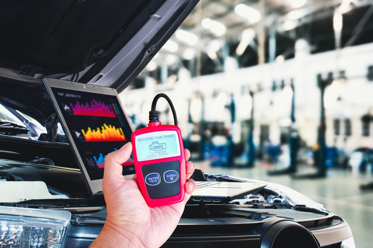 OBD2 or OBD scanner tool and laptop for engine system analysis in the auto repair shop