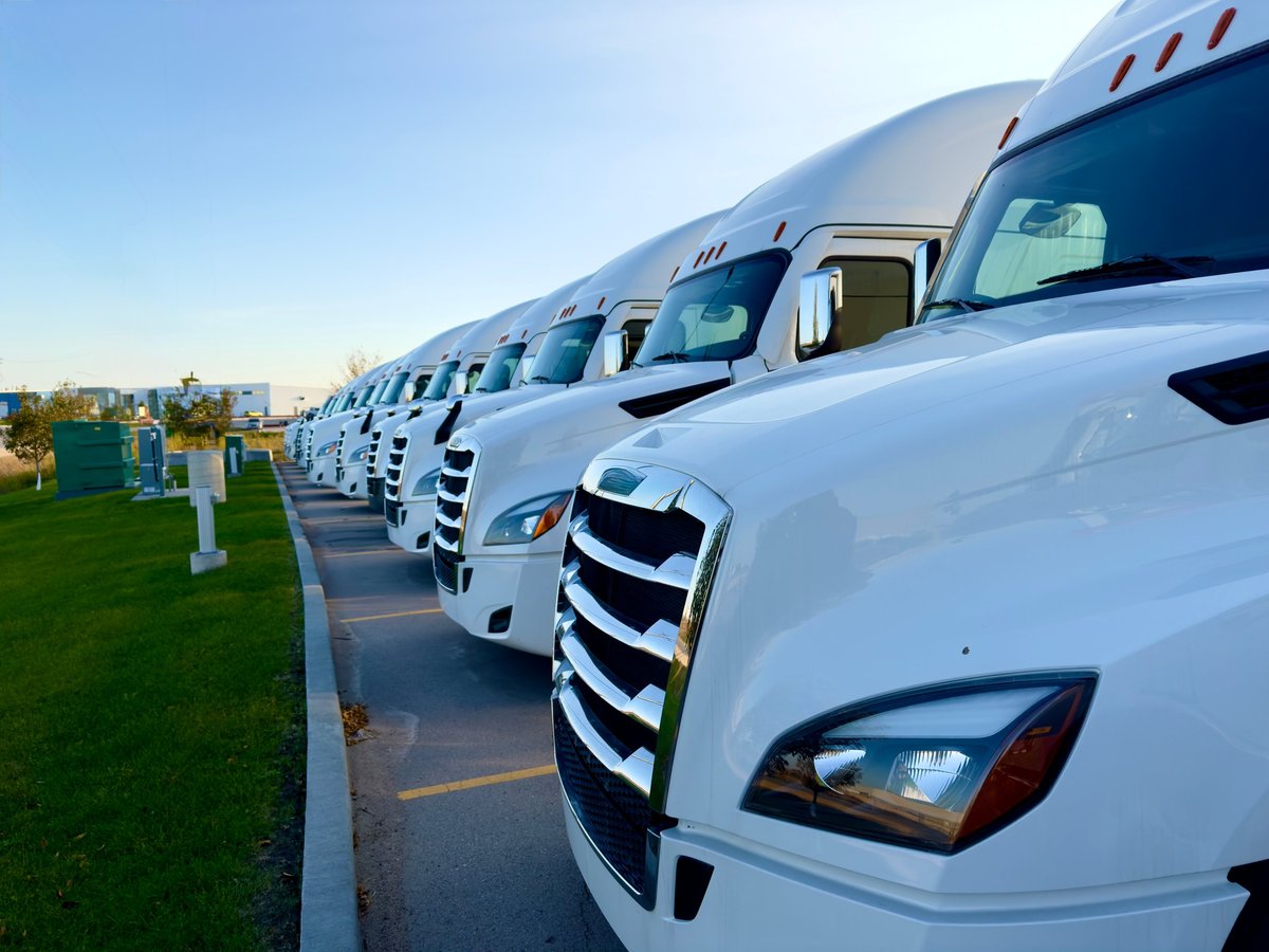 Rows of white work trucks and commercial vans in a parking lot