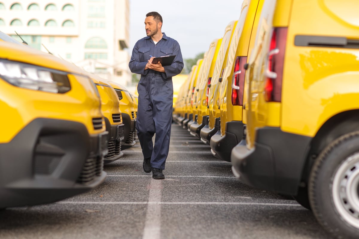 Mechanic inspecting a fleet of service vans in a workshop