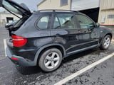 Black BMW X5 SUV side profile with alloy wheels