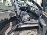 Open driver-side door showing beige interior with dashboard
